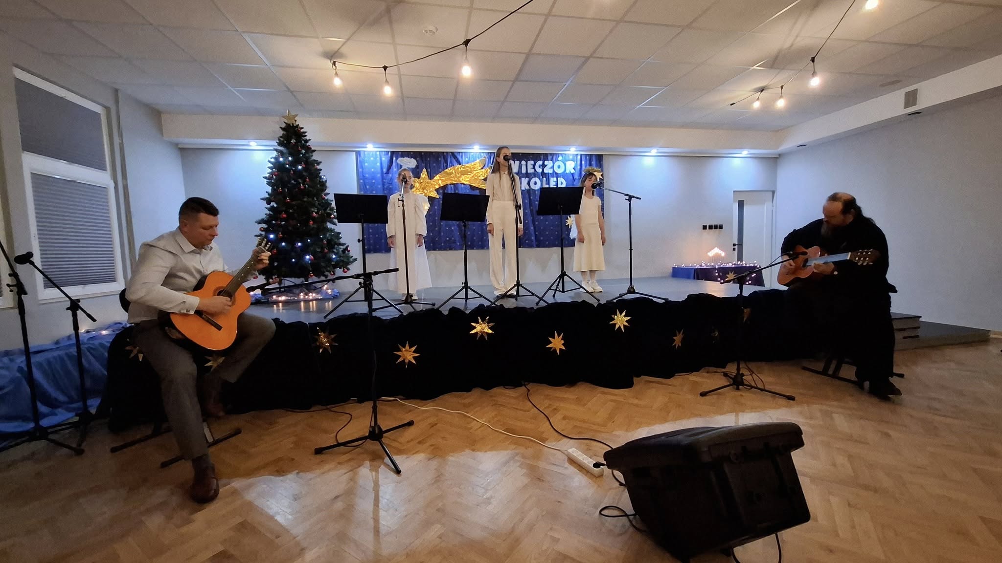 zdjęcie dziewczyek śpiewających i akopmpaniatorów gitarowych